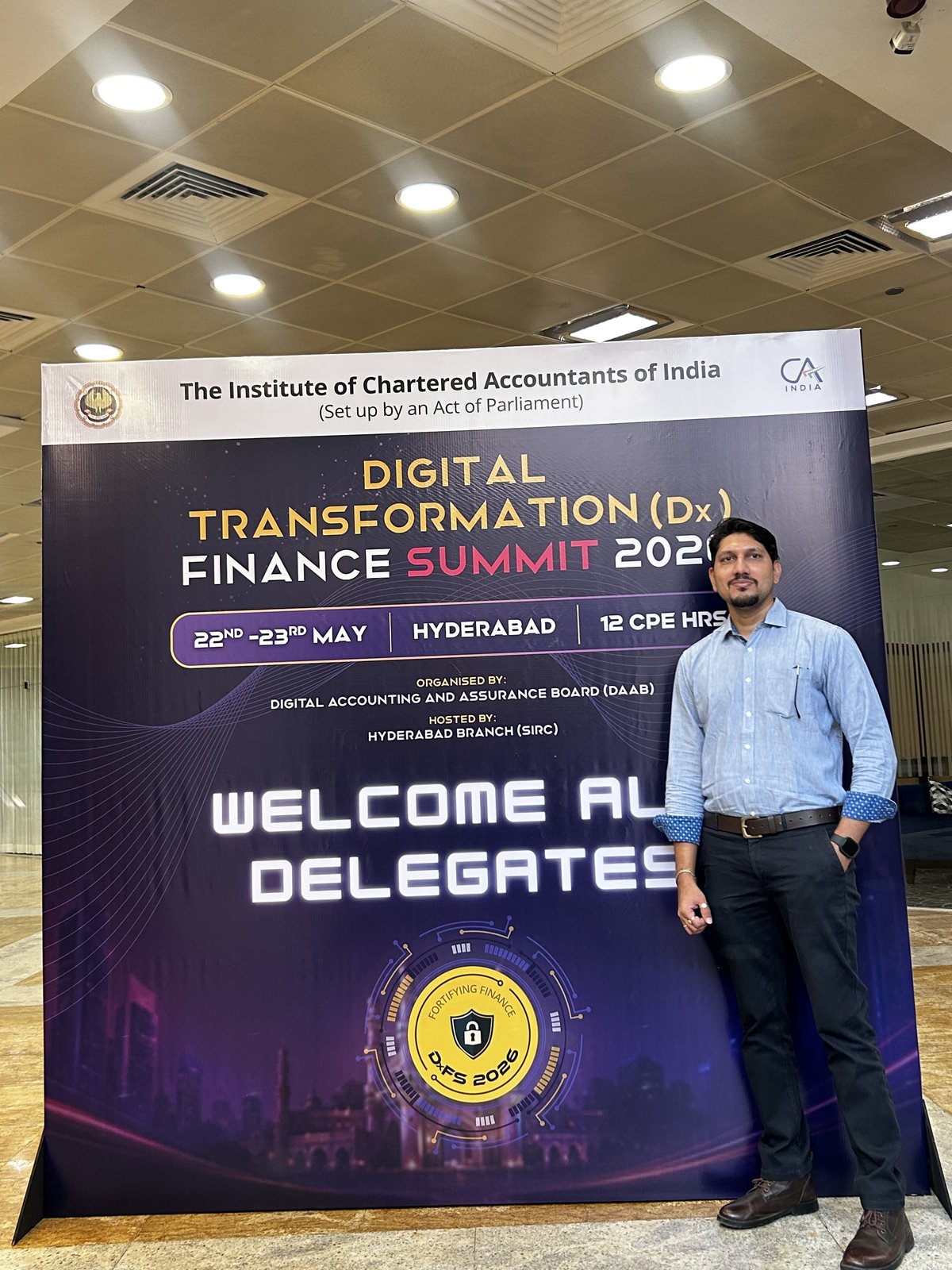 A SecComply team member at the ICAI DxFS 2026 welcome backdrop, Hyderabad